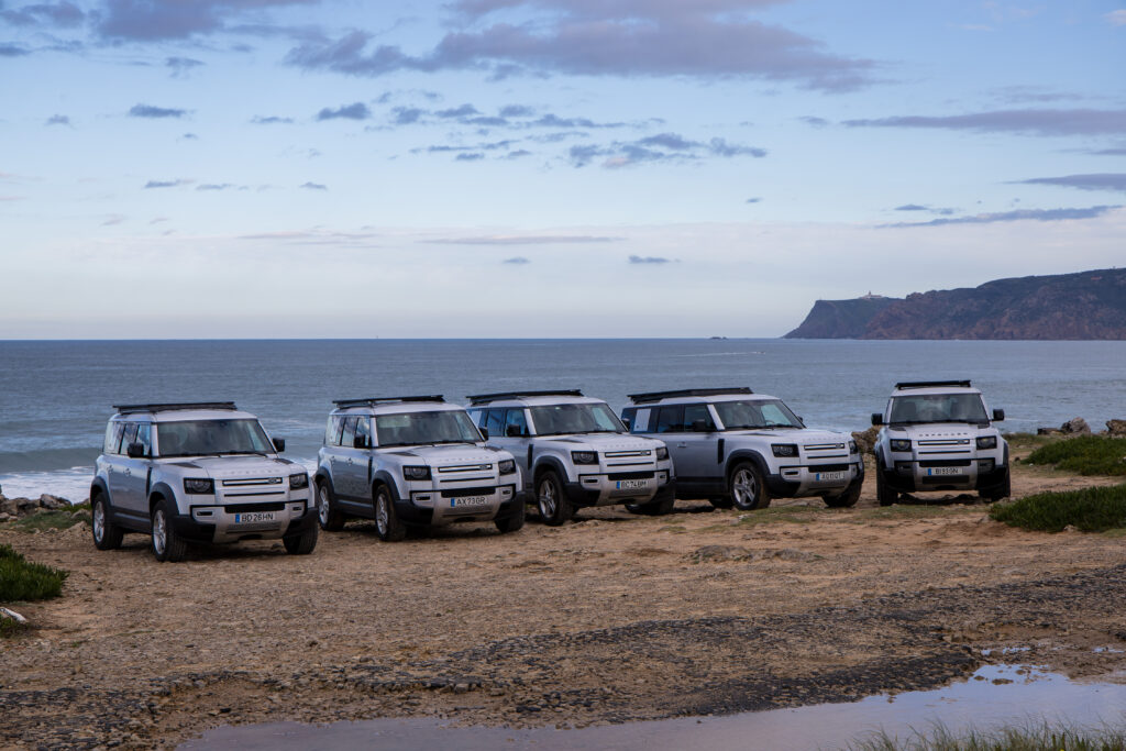 Frota Land Rover Defender da DRIVEXPLORE com vista para o Atlântico em Portugal